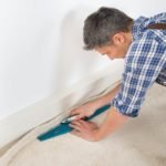 repair and renovation man installing new carpet